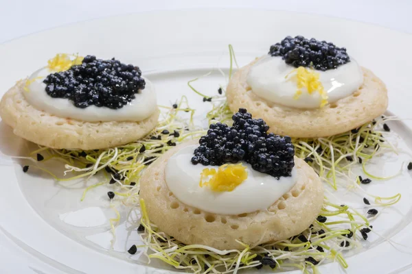 Krep krema ve pırasa lahanası bir yatak üzerinde kızarmış balık havyar. Beyaz tabakta yemek. metin için yer.