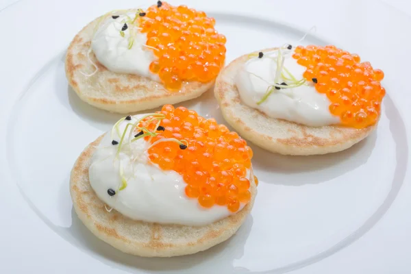 Krep krema ile üzerinde kırmızı balık havyar. Beyaz tabakta yemek. metin için yer.