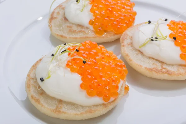 Krep krema ile üzerinde kırmızı balık havyar. Beyaz tabakta yemek. metin için yer.