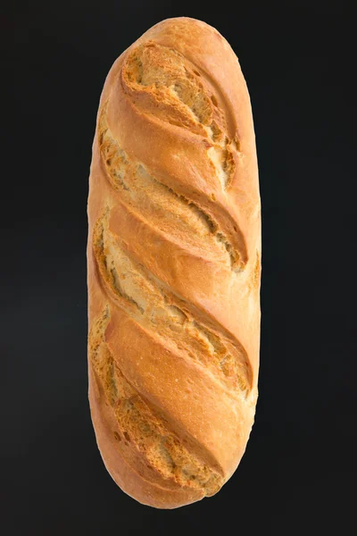 French bread in the shape of the stick on a black background — Stock Photo, Image