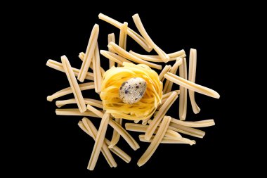 quail eggs in a nest on a black background. Food image with space for text clipart