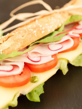 sandviç Fransız baget, peynir, jambon, domates, turp, marul portre. ev yapımı yemek. gevrek ekmek