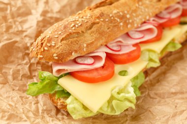 sandviç Fransız baget, peynir, jambon, domates, turp, marul portre. ev yapımı yemek. gevrek ekmek