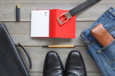 ahşap tahta üstten görünüm üzerinde yalan erkekler şeyler ayarlayın. Ayakkabı, kemer, gömlek, çanta, defter