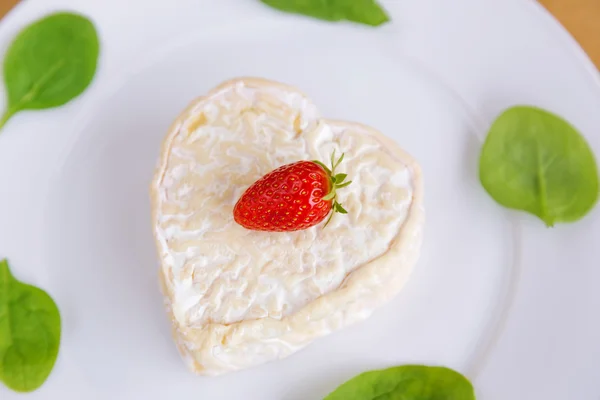 Strawberries and cheese in the shape of hearts and spinach — Stock Photo, Image