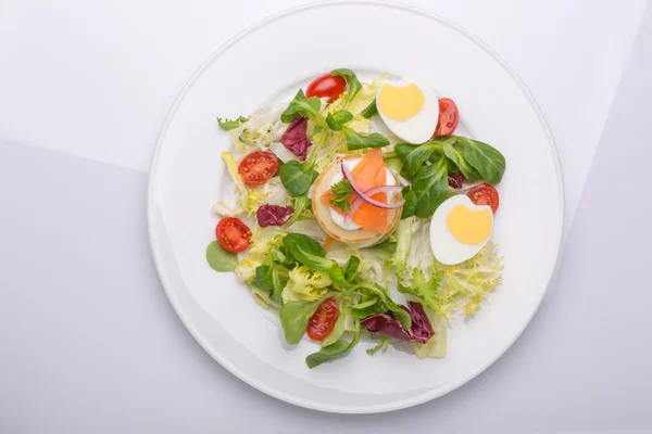 La ensalada verde con los huevos en forma del corazón, el salmón, los tomates de guinda —  Fotos de Stock