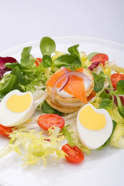 La ensalada verde con los huevos en forma del corazón, el salmón, los tomates de guinda —  Fotos de Stock