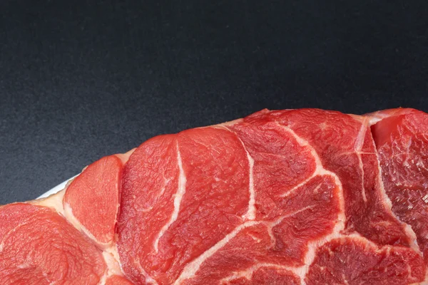 Un pezzo di carne di manzo cruda con l'osso al centro — Foto Stock