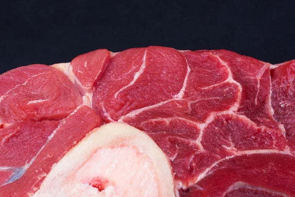 Un pezzo di carne di manzo cruda con l'osso al centro — Foto Stock