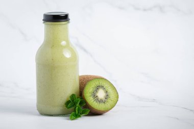 Beyaz zemine bir şişe kivi suyu.