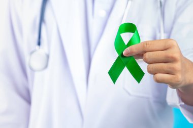 World Mental Health Day;doctor's hand holding green ribbon 