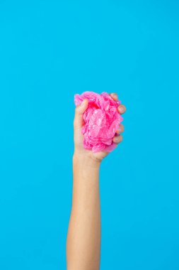 Mavi arka planda el ele tutuşan plastik çanta.