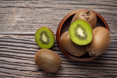 Taze kivi, ikiye bölünmüş, ahşap bir kase koy.