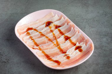 sıcak çömlek shabu; taze dilimlenmiş domuz eti tabakta.