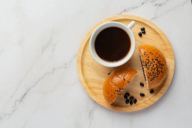 Kahveyle servis edilen ahşap tabağa konmuş siyah fasulye ezmeli çörekler.