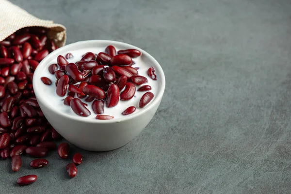 red bean coconut milk dessert in white bowl put next to the sack bag of red bean