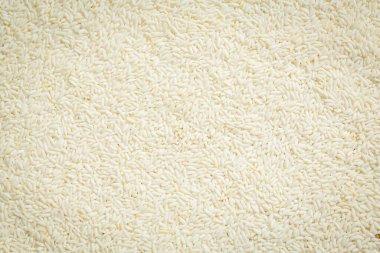 Çiğ beyaz pirincin arka planı tüm zemine yayıldı..