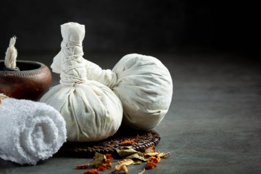 Bitkisel kompres ve bitkisel kaplıca tedavi ekipmanları koyu zemine konur.