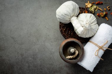 Bitkisel kompres ve bitkisel kaplıca tedavi ekipmanları koyu zemine konur.