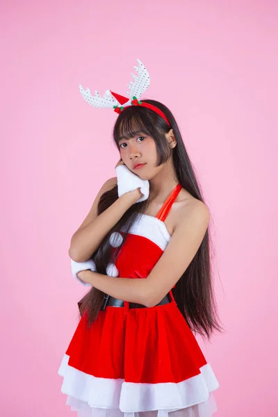 ピンクの背景にクリスマスの衣装を着た可愛い女の子 — ストック写真