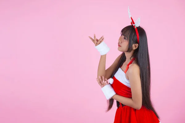 ピンクの背景にクリスマスの衣装を着た可愛い女の子 — ストック写真