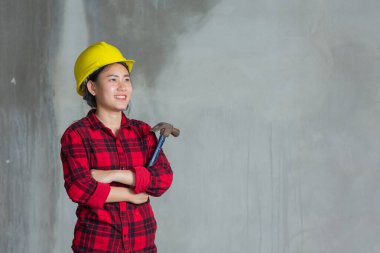 İnşaat alanında çekiç tutan işçi kadın.