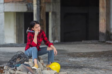 Çalışan kadın inşaat alanında oturuyor ve rahatlıyor, İşçi Bayramı konsepti