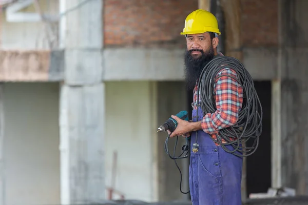 Workers holding electric drill in construction site,Labor day concept