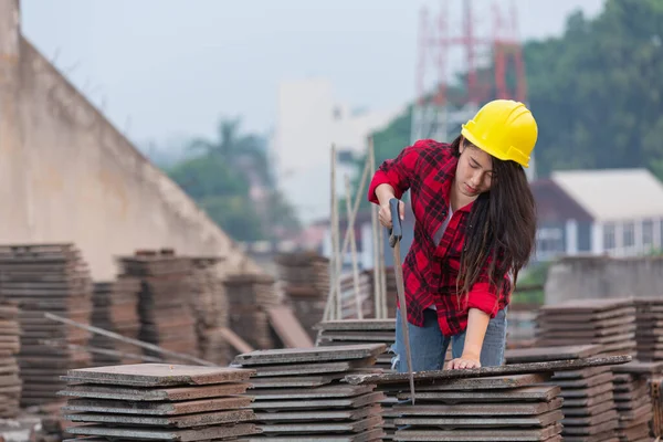 Workers woman worker sawing wood in construction site,Labor day concept