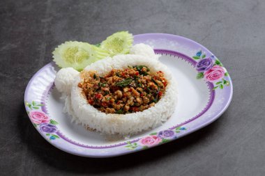 Beyaz arka planda kızarmış domuz ve fesleğenle kaplanmış pirinç.