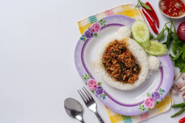 Beyaz arka planda kızarmış domuz ve fesleğenle kaplanmış pirinç.