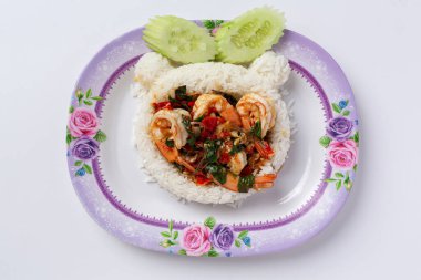 Beyaz arka planda kızarmış karides ve fesleğenle kaplanmış pirinç.