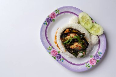 Üzerine kızarmış midye ve beyaz arka planda fesleğen konmuş pirinç.