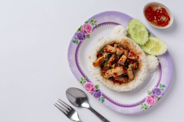 Beyaz arka planda kızarmış domuz ve fesleğenle kaplı pilav.