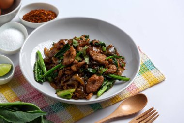 Soya soslu kızarmış pirinç eriştesi ve beyaz arka planda domuz eti.