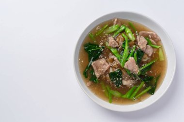 Beyaz arka planda sosa batırılmış domuz etli kızarmış şehriye ve lahana.