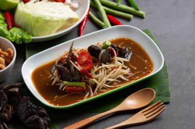 Koyu arkaplanda yengeç olan Papaya Salatası