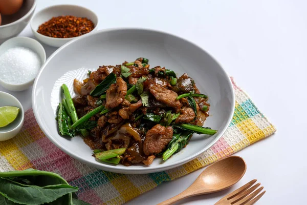 Soya soslu kızarmış pirinç eriştesi ve beyaz arka planda domuz eti.