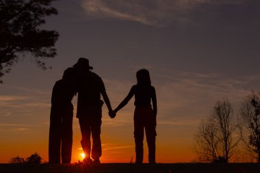 Genç çift dağda günbatımının tadını çıkarıyor.