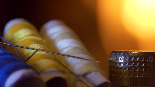 Thread Spools Berwarna Benang Terletak Atas Meja Terhadap Cahaya Api — Stok Video