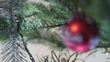 Tatil sezonu, yeni yıl. Noel süsleri renkli ışıklarla çevrili Noel ağacına asılır. Yakın çekim..