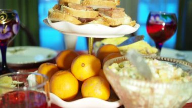 Tatil sezonu. Tatil için dekore edilmiş çeşitli yemek ve içeceklerle dolu bir masa. Kamera hareket ediyor. Yakın çekim..