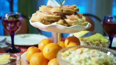 Tatil sezonu. Tatil için dekore edilmiş çeşitli yemek ve içeceklerle dolu bir masa. Kamera hareket ediyor. Yakın çekim..