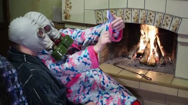 感染症 コヴィト パンデミックの間の女性と男性は ガスマスクで暖炉の近くに座り 電話で自撮りをする クローズアップ撮影 — ストック動画