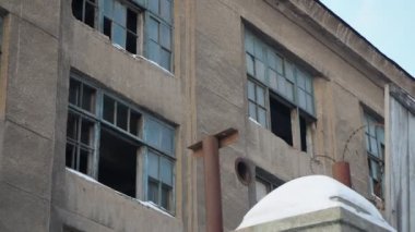 Kışın terk edilmiş eski bir sanayi binası. Kamera hareket ediyor..