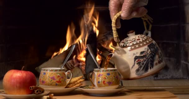 Tea Person Pours Tea Cups Standing Table Background Fireplace Flame — Stock Video