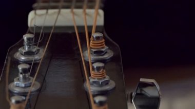 Bir müzik aleti. Şöminenin arka planında gitar telleri var. Kamera hareket ediyor. Yakın çekim..