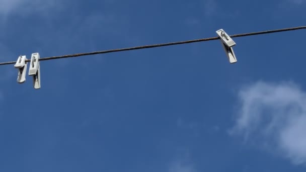 一个抽象 绳子上的衣针在蓝天上摆动 特写镜头拍摄 — 图库视频影像
