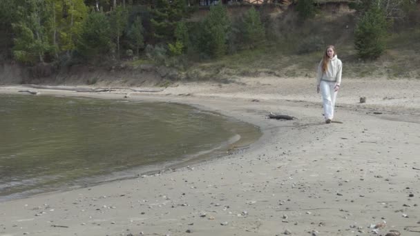 慢动作一个身穿白衣的年轻女子沿着沙滩海岸走着 西伯利亚Ob河 — 图库视频影像