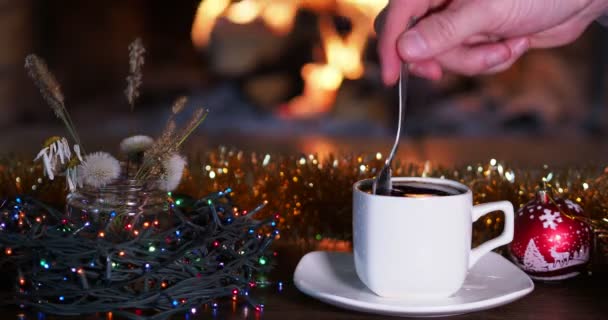 Holiday Man Puts Sugar Cup Coffee Stirs Background Fireplace Festive — Stock Video
